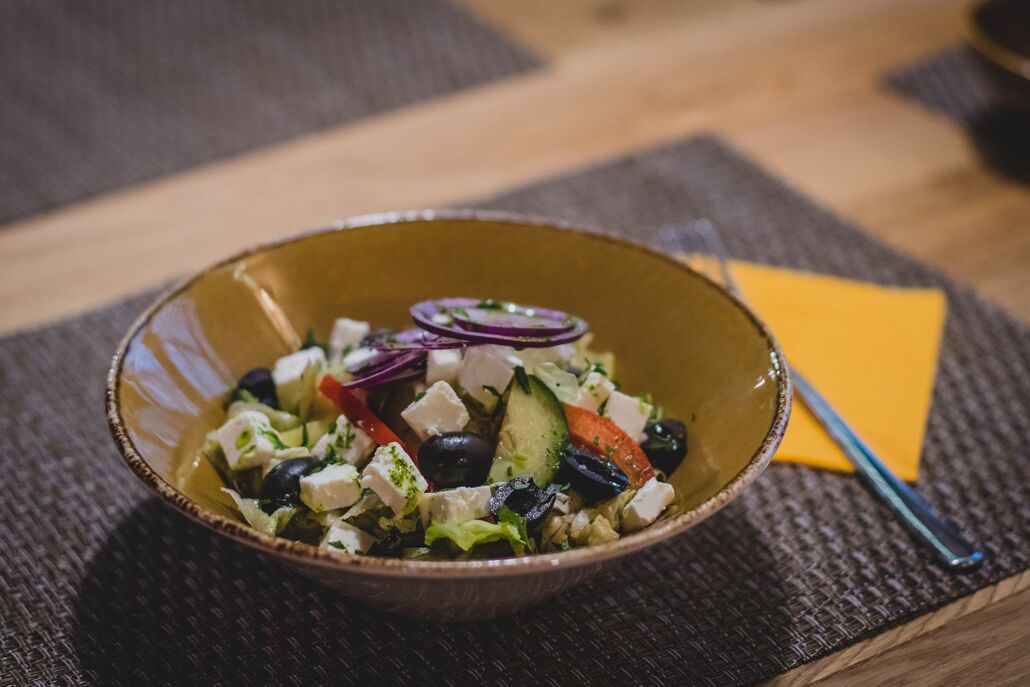 Greek salad with tomatoes, cucumber, olives and a block of feta